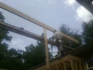 Carpenter setting a ridge beam over a new addition frame — Ice Dam Removal by Roofing Brothers in Norborne