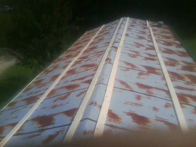 Rusted metal roof panels with new wood purlins before replacement — Storm Damage Roof Repair in Norborne by Roofing Brothers