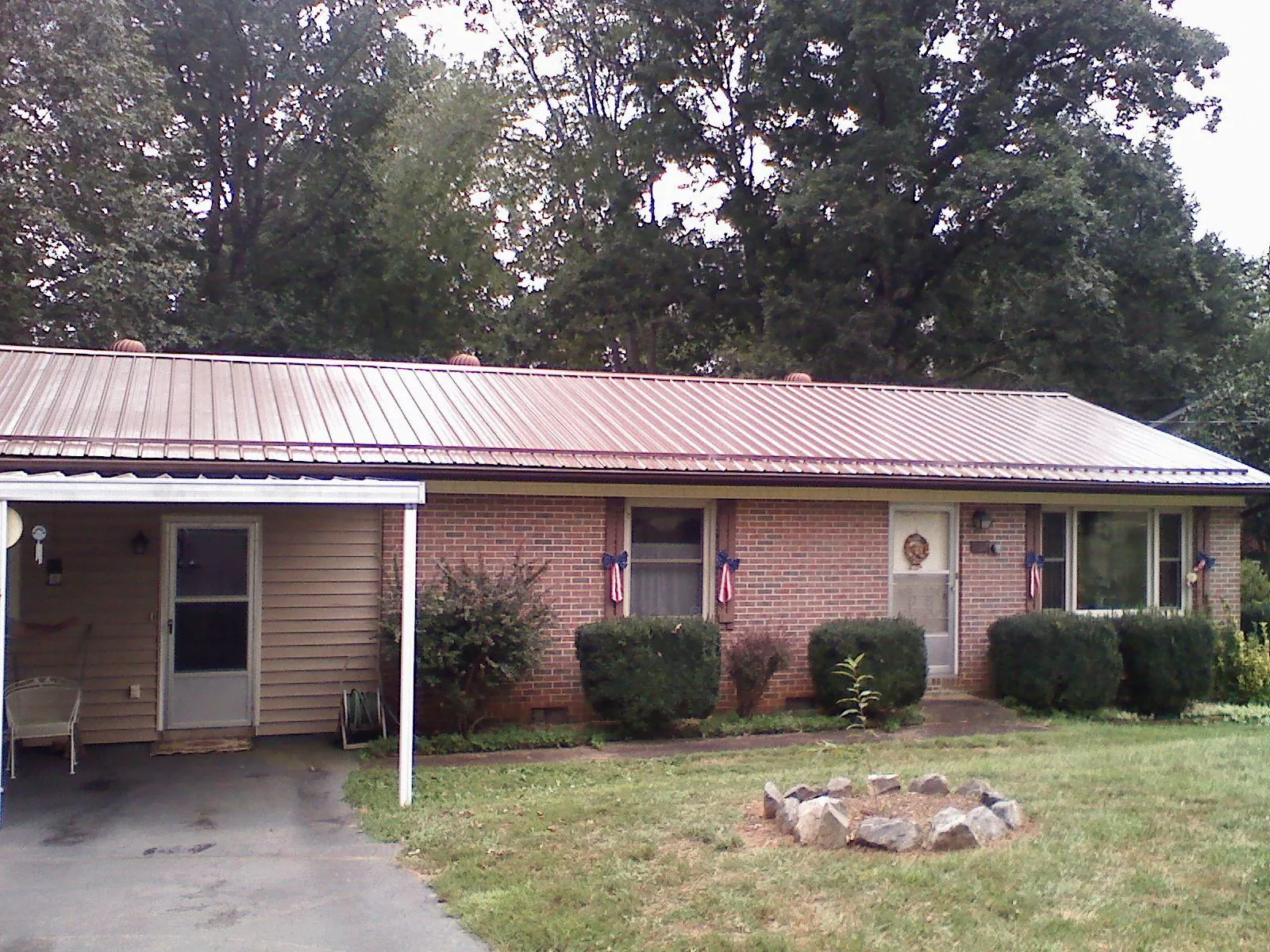 Bronze metal roof and carport on a brick ranch home — Roof Repair work by our crew in Norborne